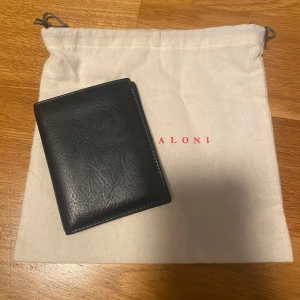 Luca Faloni korthållare i äkta italienskt läder - Säljer en nästintill oanvänd korthållare från Luca Faloni, handgjord i Florens av 100 % full grain vegetabilgarvat läder från Santa Croce. Fyra kortfack och fyra extra fickor för sedlar – allt i en kompakt och stilren design som åldras vackert med tiden.  Medföljer: kvitto, dust bag Nypris: 1400 kr Mitt pris: 650 kr