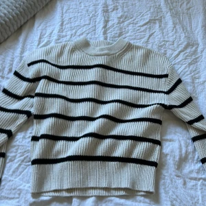 Vit och svart randig tröja från H&M - Säljer en stilren vit tröja med svarta ränder från H&M. Tröjan är ribbad och har långa ärmar, perfekt för en avslappnad look. Passar bra till både jeans och kjol. 🖤🤍