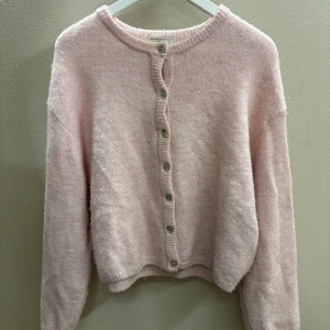 Rosa kofta från Gina tricot  - Mysig rosa kofta från Gina tricot med knappar framtill. Den har en rund halsringning och långa ärmar, perfekt för kyligare dagar. Koftan är gjord i ett mjukt material som ger en skön känsla! Inte använd många gånger så relativt ny, kameran gör att den ser gråare ut🩷skriv om det är några funderingar! 🥰