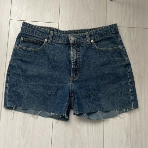Jeansshorts från Marc O'Polo - Snygga jeansshorts från Marc O'Polo i en klassisk blå denim. De har en fransig kant nedtill och femficksdesign. Perfekta för en avslappnad stil.