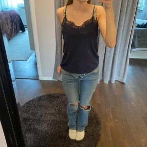 Mörkblå linne med spetsdetaljer - Ett jätte fint spets linne. Har aldrig blivit använt och är i nyskick. 