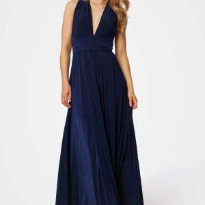 Marinblå långklänning - Säljer min balklänning! Elegant marinblå långklänning med omlott-design och djup v-ringning. Klänningen har en flexibel passform med knytband i midjan och kan stylas på olika sätt för att passa olika tillfällen.