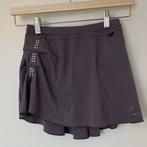 Kjol från Passionice - Snygg kjol från Passionice med stenar på framsidan. Mycket bra skick, använd endast fåtal gånger. Går ej att köpa från hemsida. Nypris: 600kr, mitt pris: 300kr. I storlek 150. 