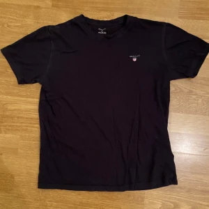 Gant T-shirt - Svart Gant T-shirt i storleken 170. Har bäxt ur den så kommer ej till användning längre! Hör gärna av er!