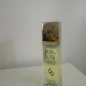 Musk by Alyssa Ashley Eau Parfumée - Elegant och tidlös doft från Alyssa Ashley. Flaskan är rektangulär med en stilren design och ett silverfärgat lock. Perfekt för den som älskar klassiska och mjuka dofter med en touch av musk.