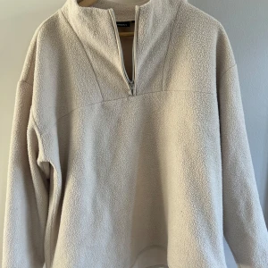 Beige fleece tröja med dragkedja - Mysig beige fleece tröja från KappAhl med halv dragkedja framtill. Perfekt för kyliga dagar med sin mjuka och varma känsla. Tröjan har en hög krage och långa ärmar.🌬️🌬️
