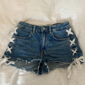 Jeansshorts med snörning - Snygga blå jeansshorts med cool snörning på sidorna och fransiga kanter. Använd fåtal gånger 