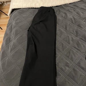 Svarta kostymbyxor från Bik Bok - Snygga svarta kostymbyxor från Bik Bok med en klassisk design. Byxorna har en rak passform och är perfekta för en stilren look. De har hällor för bälte och en diskret dragkedja framtill.