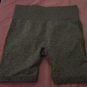 Grå träningsshorts - Snygga grå träningsshorts med tight passform. Perfekta för gymmet eller löprundan. De har en ribbad struktur och är gjorda i ett stretchigt syntetmaterial för bästa komfort och rörelsefrihet. Vet ej vart det är ifrån!!