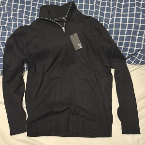 Svart half zip från 157 - Snygg svart tröja från 157 med dragkedja vid halsen. Perfekt för en stilren look. Aldrig använd prislapp sitter kvar. Snabb affär så får du den för 100.