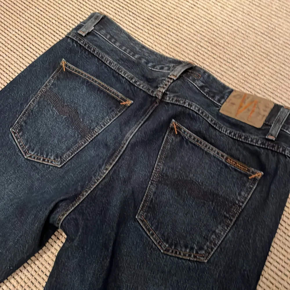 Snygga mörkblå jeans från Nudie Jeans. De har en normal passform och är asfeta. Perfekta för en clean och grich look. Nytt pris 1600, mitt pris 499 kr. Knappt använda. . Farkut & Housut.