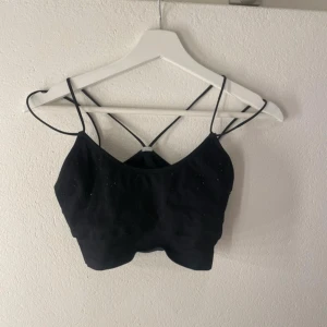Svart ribbad linnetopp - Snygg svart ribbad linnetopp med smala axelband och en stilren design. Perfekt för en trendig look eller träning. Ska flytta snart så vill gärna bli av med allt så fort som möjligt (pris kan diskuteras)💕