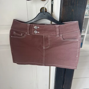 Brun minikjol  - Jättesnygg brun minikjol i storlek 36 med vita sömmar och två knappar fram. Är snålt använd 🤎