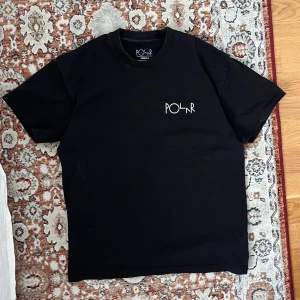 Svart t-shirt från Polar - Säljer en svart t-shirt från Polar med ett unikt tryck i vitt på baksidan. T-shirten har korta ärmar och en normal passform. 