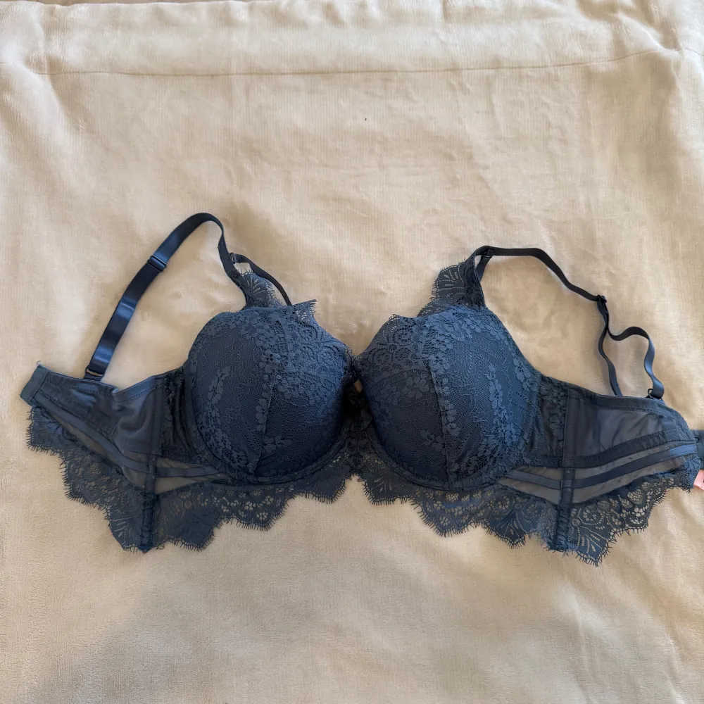 Superfin blå BH från Hunkemöller med vacker spetsdetalj och en liten rosett framtill. Den är lite mindre i storleken. På bilden så hade jag ungefär 75D i BHstorlek. Den är använd vid väldigt få tillfällen. Nypris 599kr. . Yläosat.