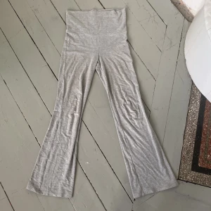 Grå byxor från Gina Tricot - Snygga grå byxor från Gina Tricot med en bekväm passform. Byxorna har en hög midja som går och vika ner och är tillverkade i ett mjukt material som ger en skön känsla. Perfekta för en avslappnad stil. 