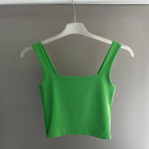 Grön linnetopp från Amisu - Snygg grön linnetopp från Amisu. Perfekt för sommardagar med sin enkla och stilrena design. Toppen har breda axelband och en rak skärning vid halsen.