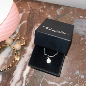  Thomas Sabo silverhalsband med berlock - oanvänt silverhalsband från Thomas Sabo med ett hängsmycke i form av en fyrklöver med rhinestones. Levereras i originalförpackning. Orginalpris 1000kr. 