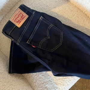 Mörkblå Levi's jeans stl 25 - Snygga mörkblå Levi's jeans med hög midja och bootcut-stil. Klassisk design. Använda endast 1 gång 