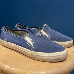 Blå sneakers/loafers från Gant - Blå sneakers/loafers från Gant med vit sula och diskret logga ovanpå. Inga större tecken på användning, storlek 39, pris kan diskuteras