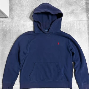 Ralph Lauren Mörkblå Hoodie - Perfekt skick, äkta såklart. Använts ett par gånger. Storlek L youth, vilket motsvarar ungefär storlek S. Skriv vid minata fundering.
