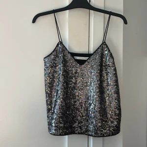 Glittrig paljettopp från & Other Stories - Super snygg glittrig paljettopp från & Other Stories med tunna axelband och v-ringning. Perfekt för en festlig kväll! ✨