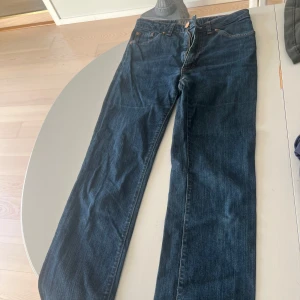 Blå jeans från Acne - Snygga blå jeans från Acne med klassisk femficksdesign och knappgylf. Perfekta för en avslappnad stil. De har en rak passform och är högmidjade. 