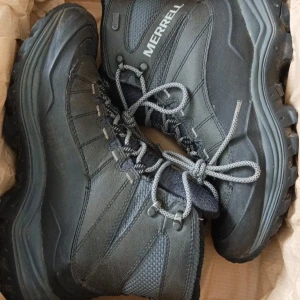 Svarta kängor från Merrell - Säljer ett par robusta svarta kängor från Merrell. De har snörning och är perfekta för kalla dagar med sin varma isolering. Kängorna har en slitstark sula och är designade för att ge bra grepp på olika underlag.