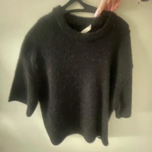 Svart stickad tröja - Mysig svart stickad tröja med rund halsringning. Perfekt för kyliga dagar och enkel att matcha med olika outfits.