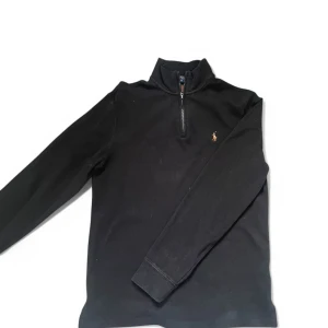Ralph Lauren Zip - En svart Ralph lauren half zip i storlek S som nu säljs pga att jag inte använder den! Säljer den för 399 kr . Den är knappt använd och det finns inga defekter. Skriv vid minsta fundering eller behov av bättre bilder! Nypris:1899 kr.