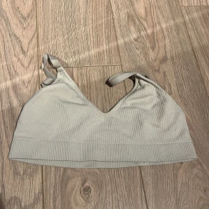 Grå ribbad linnetopp - Säljer en stilren grå ribbad linnetopp med justerbara axelband. Perfekt för en avslappnad look eller som lager under andra plagg.