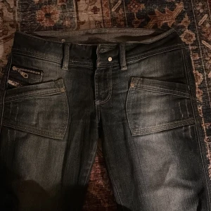 Diesel bootcutjeans - Snygga mörkblåa jeans från Diesel. Jeansen har coola dragkedjedetaljer på fickor, fram och baksida. Jeansen är väldigt låga och har en bootcut model. Pris kan diskuteras☺️