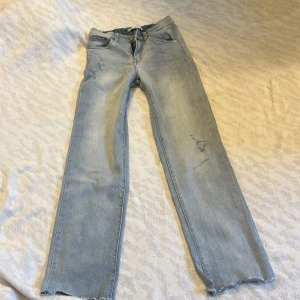Ljusblå low wide jeans - Snygga ljusa jeans från Levi's med wide leg design. De har en klassisk femficksmodell och slitna detaljer på benen. Storlek 12A/152 cm, passar mig som är 160.