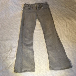 Grå bootcut jeans - Snygga grå bootcut jeans med två knappar i midjan. De har en klassisk femficksdesign och väldigt lågmidjade! storlek 152, finns inte kvar på deras hemsida eller i butiker