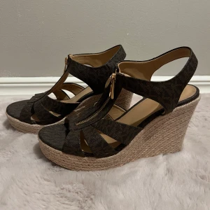 Bruna kilklackssandaler från Michael Kors - Perfekta nu till våren och sommaren!                                                                               Säljer 500kr, men kan diskuteras.