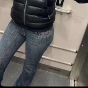 Jeans från Cross - Snygga lågmidjade jeans från Cross i en klassisk blå färg. De har en bootcut-stil och är dekorerade med broderade detaljer på bakfickorna. Pris kan diskuteras!