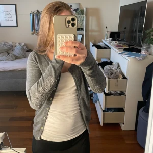 Grå kofta från Culture - Säljer en stilren grå kofta från Culture med fina broderade detaljer på ärmarna. Koftan har knappar framtill. Säljer för att den inte kommer till användning!🩷