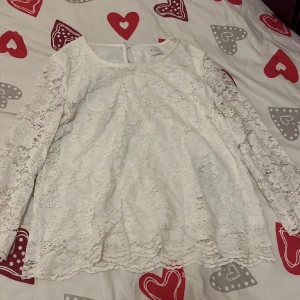 Vit spetsblus från Vila - Säljer en elegant vit spetsblus från Vila. Blusen har en rund halsringning och är perfekt för en stilren look. Den är helt i spets vilket ger en romantisk känsla. Passar utmärkt till både jeans och kjol.