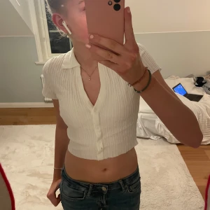 Vit ribbad kortärmad topp från H&M - Säljer en vit ribbad topp från H&M med korta ärmar och knappar framtill. Jättefin topp, aldrig använd. Strl xxs men passar xs-s💕
