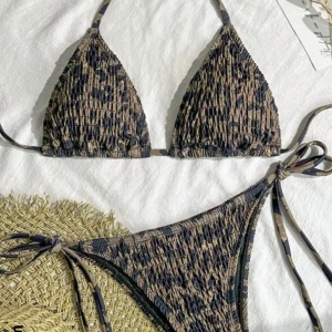 Leopardmönstrad bikini - Leopardmönster bikini i jordnära toner. Överdelen har trekantsform och knytband runt nacken och ryggen. Underdelen är en klassisk trosa med knytband. Aldrig använd eller provad, lappar och plasten i underdelen kvar med påsen den kom i!🩷 Storlek L