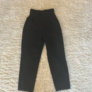 Svarta kostymbyxor från H&M - Snygga svarta kostymbyxor från H&M i storlek 34. Byxorna har en hög midja och en rak passform 