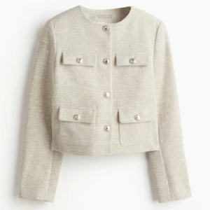 Ljusbeigemelerad kavaj - Snygg ljusbeigemelerad kavaj med knappar framtill och fyra fickor. Helt ny fortfarande i förpackning