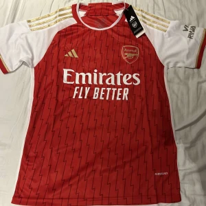 Arsenal hemmatröja Adidas röd/vit - Arsenal hemma tröja, helt nytt skick, perfekt till sommaren som vill ha en unik stil.