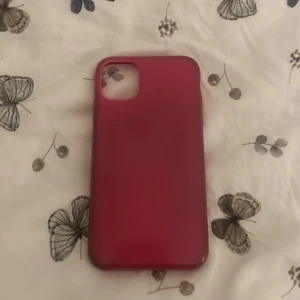 Röd mobilskal i mjukt material - Säljer ett stilrent rosa mobilskal med matt finish. Skalets form är slimmad och skyddar baksidan och kanterna på mobilen. Passar dig som vill ha en enkel men snygg look till din telefon.