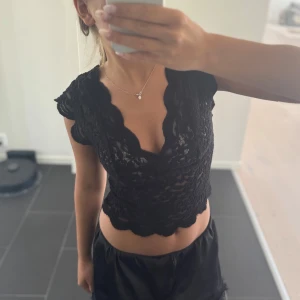 INTRESSEKOLL Svart spetsblus från Zara - Startbud på 300kr, skriv till mig hur mycket man skulle kunna ge för toppen! Supersöt svart blus från Zara i spets med v-ringning och korta ärmar. Croppad modell med vågiga kanter och transparent känsla. Perfekt att styla med jeans eller kjol för en trendig look .