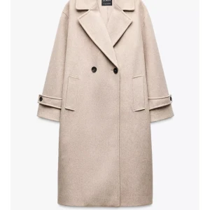 Beige kappa från Zara med knappar - SÖKER denna Stilren beige kappa från Zara med dubbelknäppning och breda slag. Jackan har raka fickor framtill och dekorativa knappar vid ärmsluten. Perfekt för dig som gillar en klassisk och clean look.  Söker denna i strl xs i båda färgerna svart o beige 