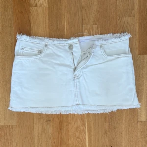 Vit jeanskjol med fransad kant - Vit kort jeanskjol med fransad kant upptill och nedtill