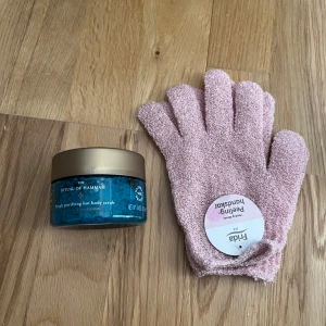 Rituals kroppsskrubb & peelinghandskar - Säljer en Ritual of Hammam deeply purifying hot body scrub med havssalt och eukalyptus i blå burk med guldfärgat lock. Medföljer ett par rosa peelinghandskar från Frida, perfekta för att exfoliera huden och få den supermjuk. Allt är nytt och oanvänt 