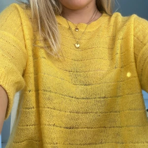 Gul mohairtröja från Marie Sixtine - Superfin gul stickad tröja från Marie Sixtine i kid mohair. Tröjan har ett luftigt, transparent stickat mönster med horisontella ränder och kortare ärmar. Perfekt för dig som gillar färg och vill ha en mysig men lätt tröja till garderoben.