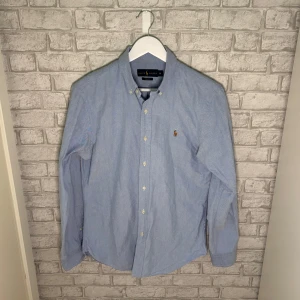 Ralph Lauren skjorta - Ralph Lauren skjorta i slim fit-modell. Skjortan har button down-krage, broderad logga på bröstet och vita knappar framtill. Perfekt för en clean och stilren look nu under sommarn. Hör av dig vid intresse 🙌